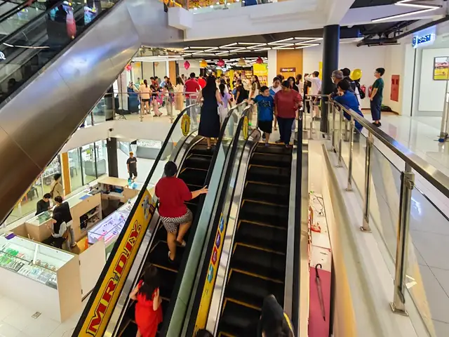 Shoppers riding the escalator up to MR. DIY